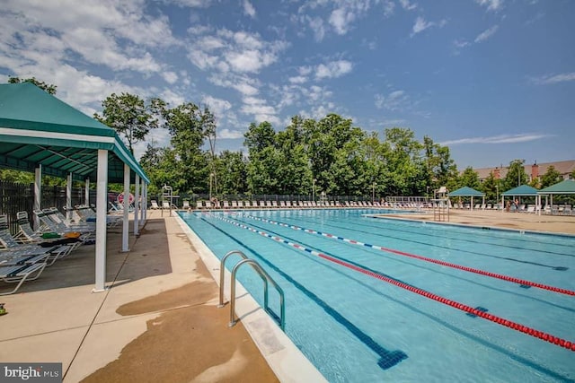 pool featuring a gazebo, a patio area, and fence