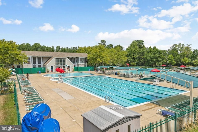 community pool featuring a patio area and fence