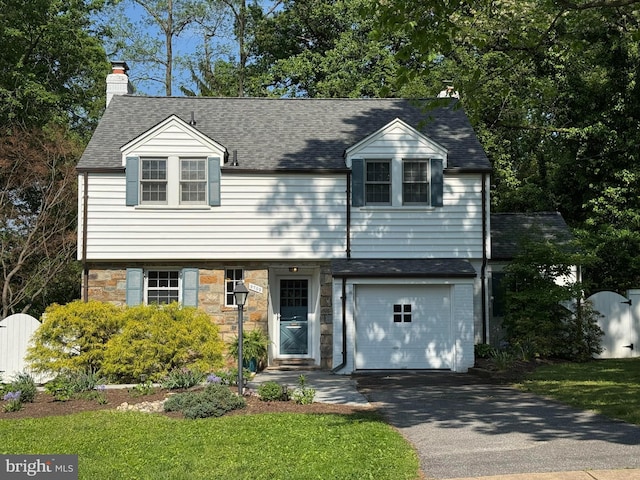 9709 W Bexhill Dr, Kensington, MD 20895 - colonial home with aphalt driveway, stone siding, roof with shingles, a chimney, and an attached garage