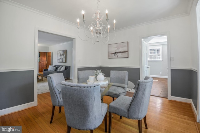 9709 W Bexhill Dr, Kensington, MD 20895 - dining space with crown molding, light wood-style flooring, baseboards, and a notable chandelier