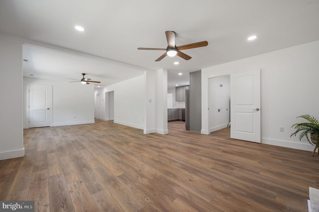 unfurnished living room with baseboards, ceiling fan, wood-type flooring, and recessed lighting