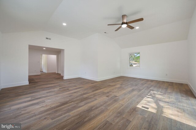 spare room with ceiling fan, dark wood-style flooring, visible vents, and lofted ceiling