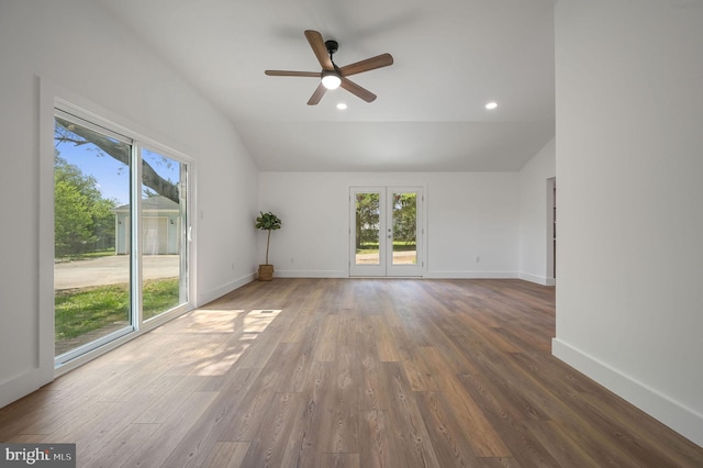 spare room with vaulted ceiling, a wealth of natural light, and wood finished floors