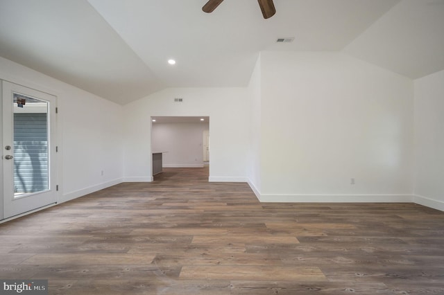 interior space with visible vents, wood finished floors, baseboards, ceiling fan, and vaulted ceiling
