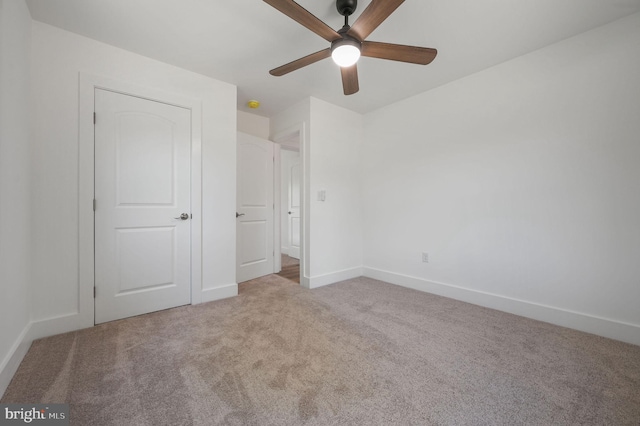 unfurnished bedroom featuring baseboards, a ceiling fan, and carpet