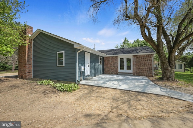 ranch-style house with brick siding, crawl space, french doors, and a chimney