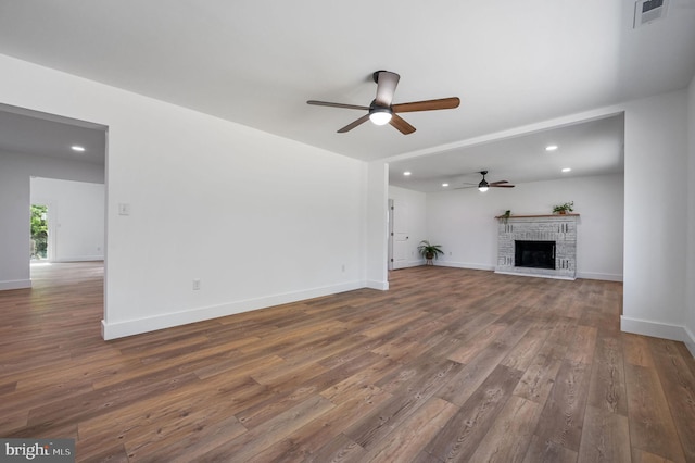 unfurnished living room featuring visible vents, a brick fireplace, dark wood-style floors, recessed lighting, and a ceiling fan