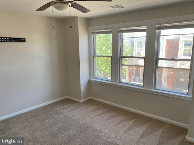 unfurnished room with baseboards, ceiling fan, a healthy amount of sunlight, and carpet