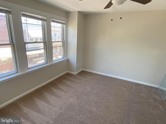 empty room featuring carpet floors, ceiling fan, and baseboards