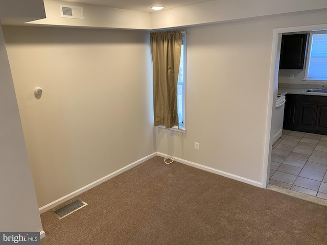 interior space featuring a sink, light colored carpet, and visible vents