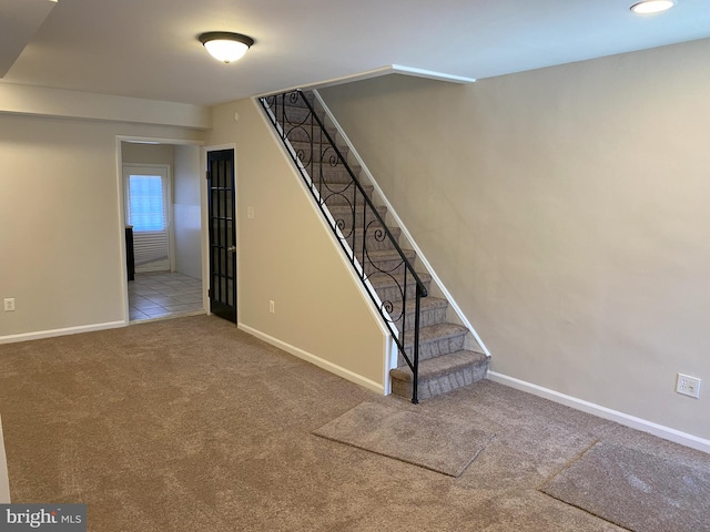 stairway featuring carpet flooring and baseboards