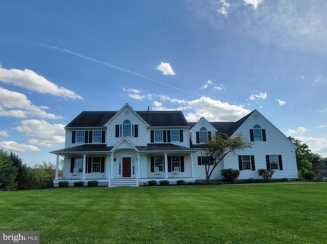 colonial home featuring covered porch and a front lawn