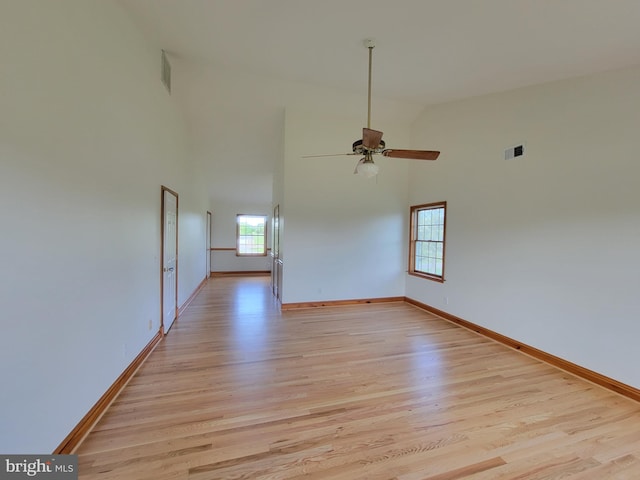 spare room with visible vents, light wood finished floors, and high vaulted ceiling