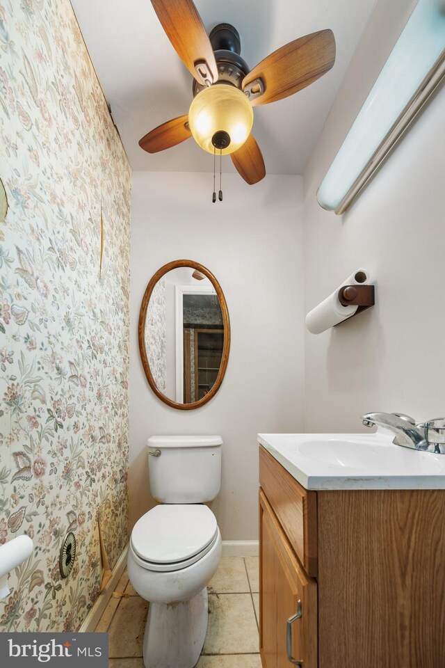 bathroom with vanity, baseboards, wallpapered walls, tile patterned floors, and a ceiling fan