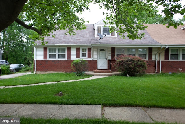 cape cod-style house with a front yard and brick siding