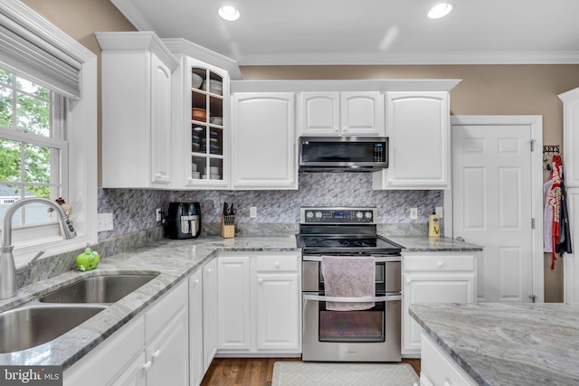 kitchen featuring a sink, white cabinets, glass insert cabinets, and appliances with stainless steel finishes