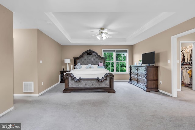 bedroom with a raised ceiling, carpet flooring, visible vents, and a spacious closet