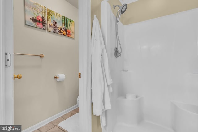 bathroom featuring walk in shower, tile patterned flooring, toilet, and baseboards
