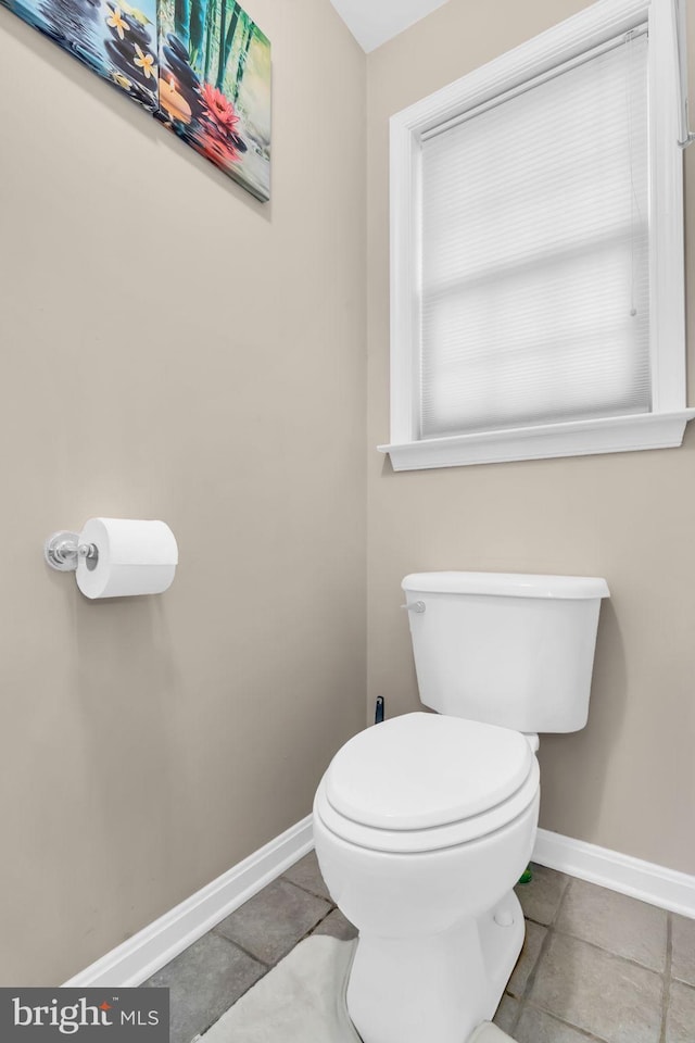 bathroom with tile patterned floors, toilet, and baseboards