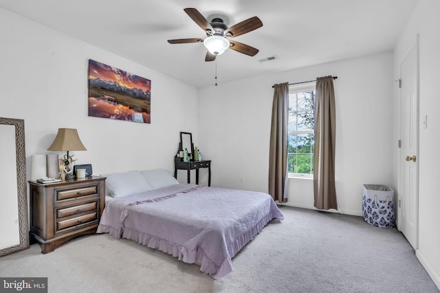 carpeted bedroom with baseboards, a ceiling fan, and visible vents
