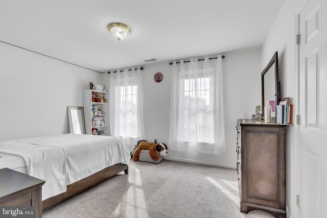 bedroom with baseboards, visible vents, and carpet
