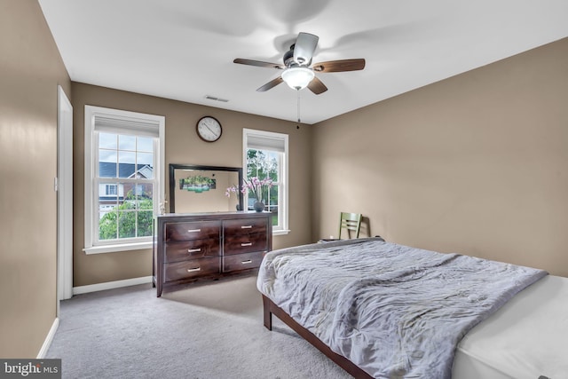 carpeted bedroom featuring visible vents, baseboards, and a ceiling fan