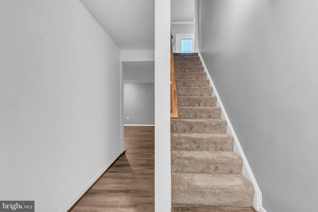 stairway with wood finished floors and baseboards