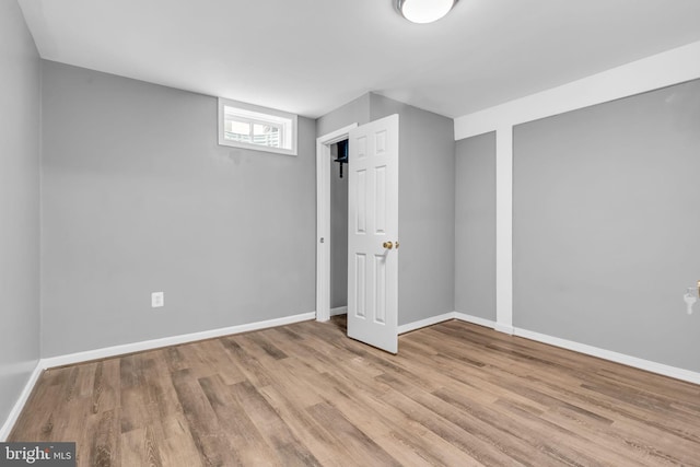 basement with baseboards and wood finished floors