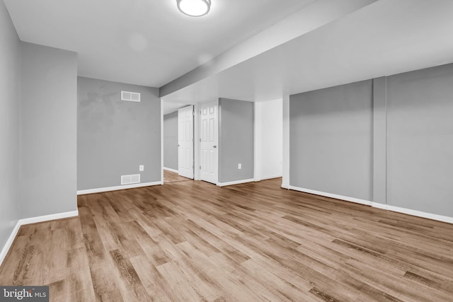 interior space with baseboards, visible vents, and wood finished floors