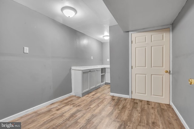 below grade area with light wood-style floors and baseboards