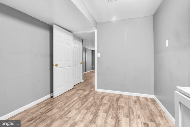 unfurnished room featuring baseboards and light wood-style flooring