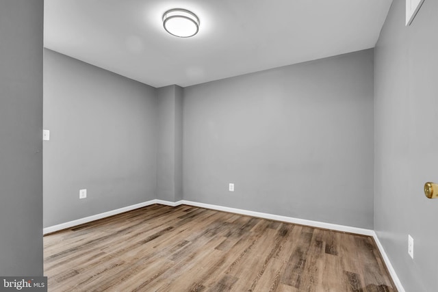 unfurnished room with baseboards and wood finished floors