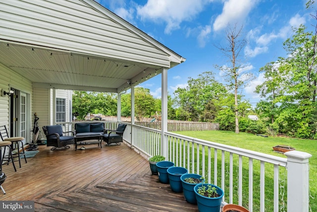 wooden terrace with outdoor lounge area, a yard, and a fenced backyard