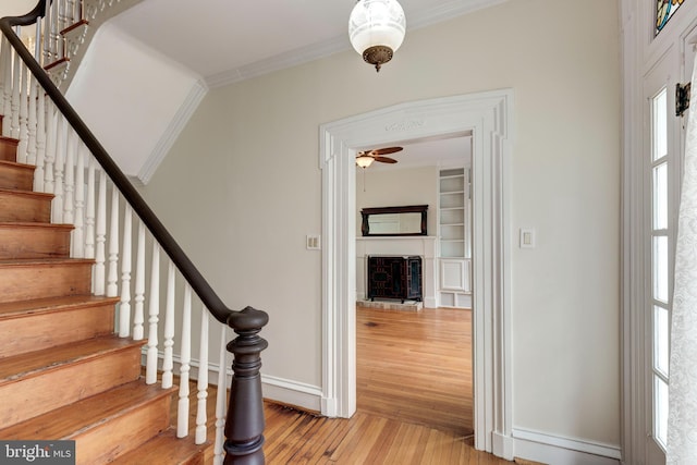 140 Pennsylvania Ave, Westminster, MD 21157 - stairs featuring hardwood / wood-style floors, crown molding, a fireplace with raised hearth, and ceiling fan