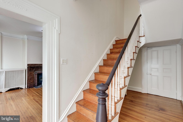 140 Pennsylvania Ave, Westminster, MD 21157 - staircase featuring hardwood / wood-style floors, a brick fireplace, and ornamental molding