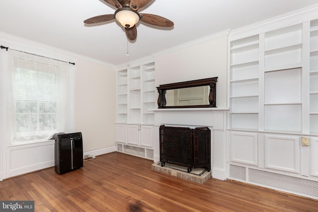 140 Pennsylvania Ave, Westminster, MD 21157 - unfurnished living room featuring a fireplace with raised hearth, built in features, wood finished floors, crown molding, and a ceiling fan