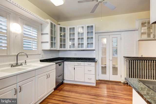 140 Pennsylvania Ave, Westminster, MD 21157 - kitchen with dishwasher, radiator heating unit, light wood-style floors, white cabinets, and tasteful backsplash