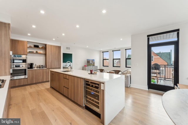 kitchen featuring modern cabinets, wine cooler, a sink, brown cabinetry, and open shelves