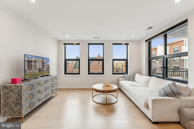 living room with light wood-type flooring, recessed lighting, and baseboards