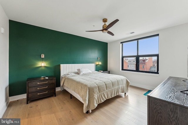 bedroom with wood finished floors, baseboards, and a ceiling fan