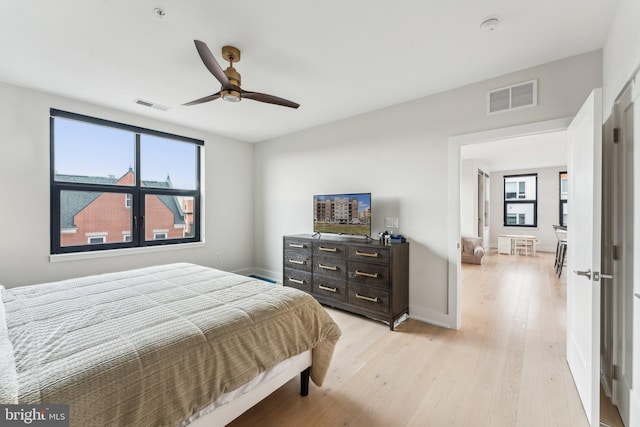bedroom featuring light wood-type flooring, a ceiling fan, and baseboards
