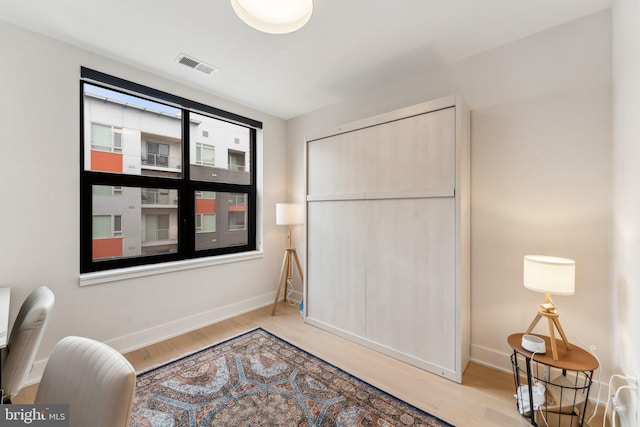 living area with baseboards and wood finished floors