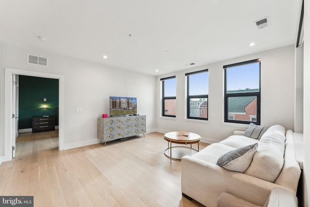 living room with light wood-type flooring, baseboards, and recessed lighting