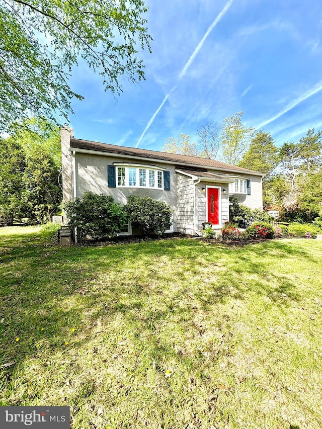 877 Salford Station Rd, Schwenksville, PA 19473 - view of front of home with a front yard, a chimney, and stucco siding