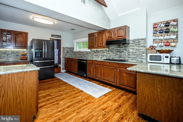 877 Salford Station Rd, Schwenksville, PA 19473 - kitchen with black appliances, wood finished floors, decorative backsplash, under cabinet range hood, and vaulted ceiling