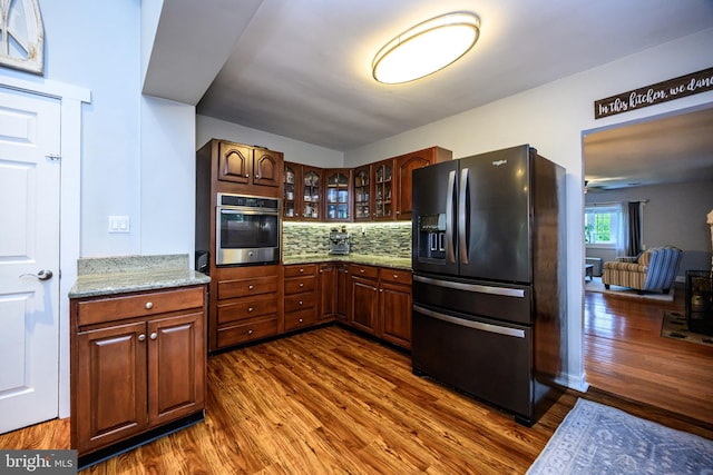 877 Salford Station Rd, Schwenksville, PA 19473 - kitchen featuring black fridge, stainless steel oven, dark wood-style flooring, glass insert cabinets, and tasteful backsplash