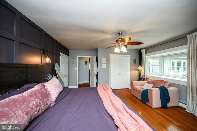 877 Salford Station Rd, Schwenksville, PA 19473 - bedroom featuring a baseboard heating unit, wood finished floors, a ceiling fan, and two closets