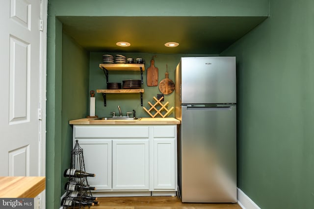 877 Salford Station Rd, Schwenksville, PA 19473 - kitchen featuring freestanding refrigerator, wood counters, a sink, white cabinets, and light wood finished floors