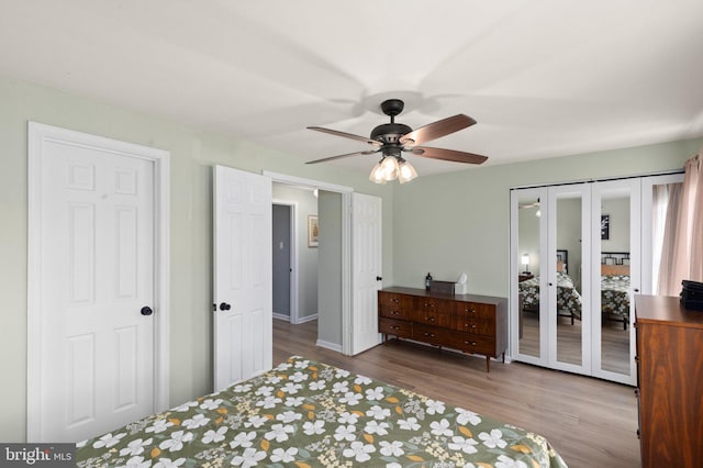 bedroom featuring baseboards, ceiling fan, french doors, and wood finished floors