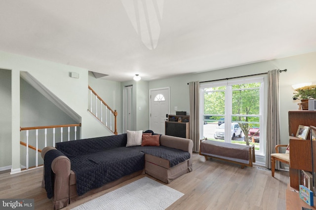 living area with light wood finished floors and stairs